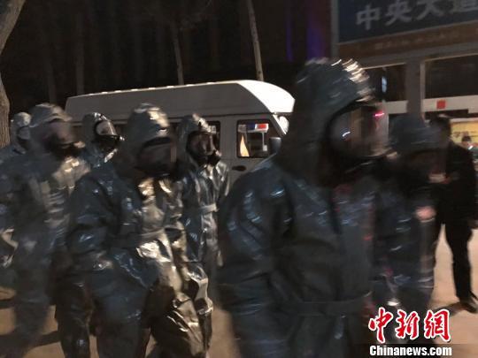 十几名身着防护服的人员头戴面具进入事发地。　胡健 摄